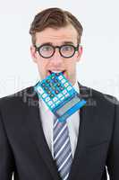 Geeky businessman biting calculator