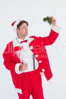 Geeky hipster in santa costume holding mistletoe