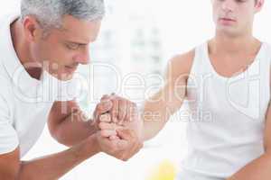 Doctor examining his patient hand