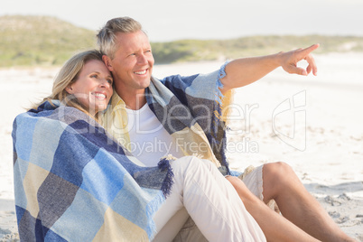 Happy couple wrapped up in blanket