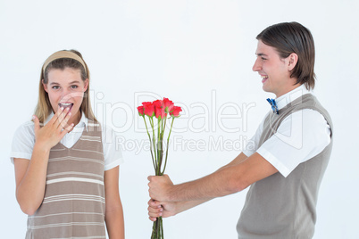 Geeky hipster offering red roses to his girlfriend