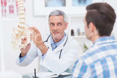 Doctor showing his patient a spine model