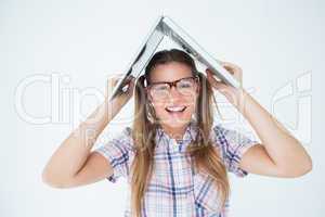 Geeky hipster holding her laptop over her head