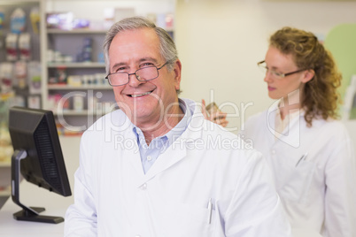 Senior pharmacist smiling at camera