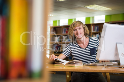 Student studying in the library with computer