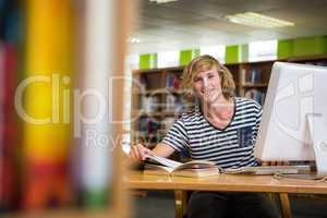 Student studying in the library with computer