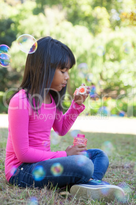 Cute little girl blowing bubbles