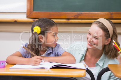 Teacher helping pupil in classroom