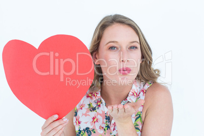 Woman holding heart card and blowing kiss
