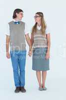 Geeky hipster couple holding hands and looking at each other