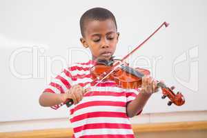Focus pupil playing violin in classroom