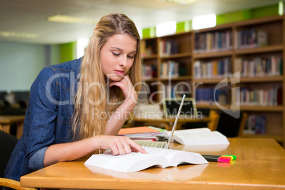 Student studying in the library with laptop