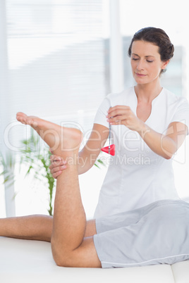 Physiotherapist using reflex hammer