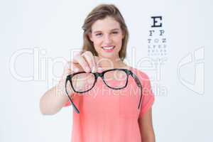 Hipster showing glasses next to an eye test