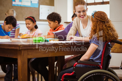 Teacher helping a disabled pupil