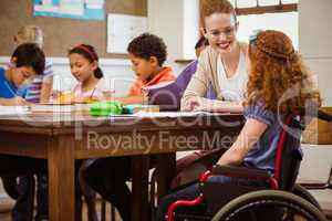 Teacher helping a disabled pupil