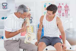 Doctor showing anatomical spine to his patient