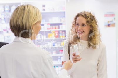 Costumer showing medicine jar to pharmacist