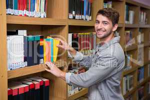 Student picking a book from shelf in library