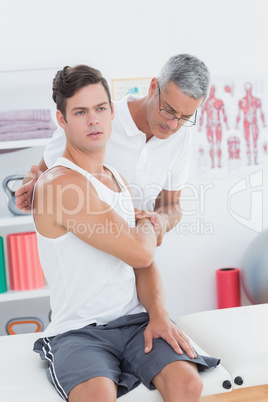 Doctor stretching a young man arm