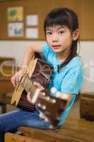 Cute pupil playing the guitar