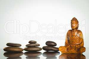Wooden buddha statue with balancing pebbles