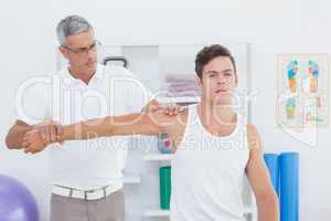 Doctor stretching a young man arm