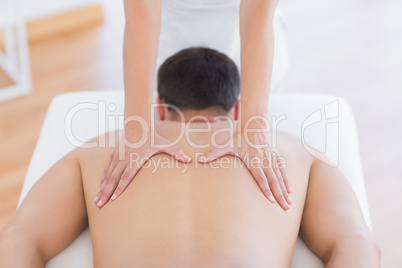 Physiotherapist doing back massage to her patient