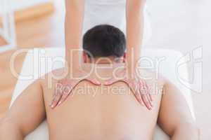 Physiotherapist doing back massage to her patient