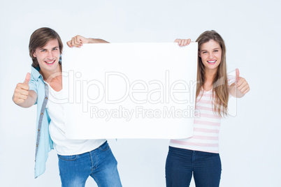 Hipster couple holding poster