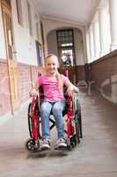 Cute disabled pupil smiling at camera in hall