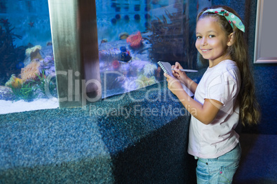 Cute girl looking at fish tank