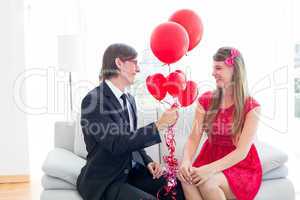 Cute geeky couple with red balloons
