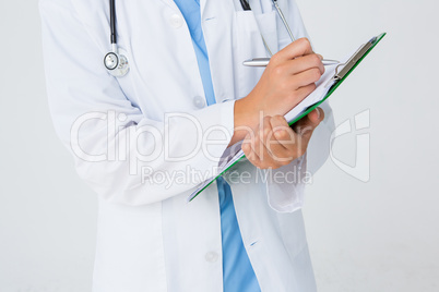 Doctor writing on clipboard