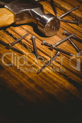 Hammer and nails laid out on table