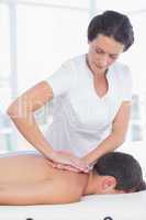 Physiotherapist doing back massage to her patient