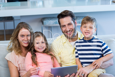 Happy family on the couch together using tablet