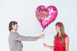 Geeky hipster offering red heart shape balloon to his girlfriend