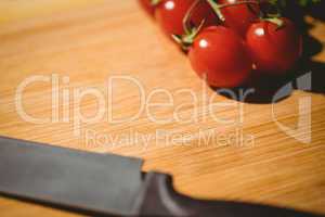 Cherry tomatoes and knife on chopping board