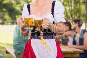 Pretty oktoberfest girl holding beer tankards