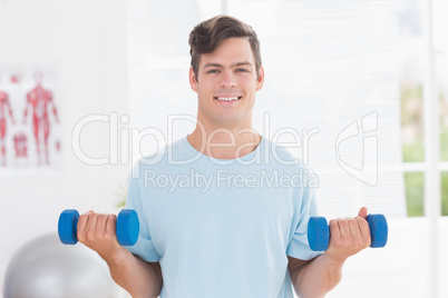 Young man training with dumbbells