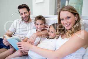 Happy family on the bed reading book