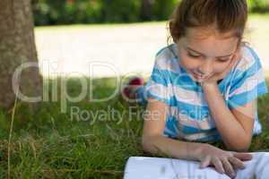 Cute little girl reading in park