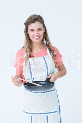 Happy hipster woman holding frying pan