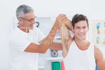 Doctor stretching a young man arm