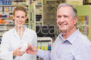 Pharmacist and costumer smiling a camera