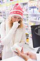 Sick girl with scarf and colorful hat giving bottle of drug