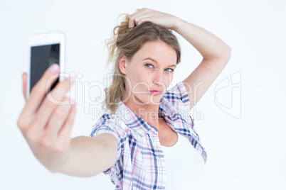 Pretty hipster taking selfie with smartphone