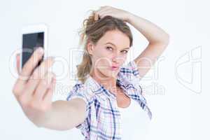 Pretty hipster taking selfie with smartphone