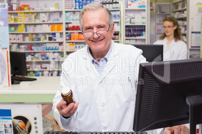 Pharmacist holding medicines looking at camera